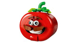 LEGO red tomato head model front view with green stem, eyes, moustache and smiling mouth