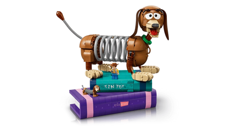 LEGO Slinky Dog model displayed on stacked purple and turquoise book builds with small character figures