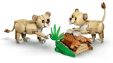 Two LEGO cub models beside a log habitat build with green plants