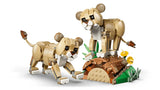Two LEGO lion cub models beside a log and flower habitat build