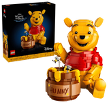 LEGO Winnie the Pooh 43300 display model with Hunny pot, bees and product box shown beside the seated Winnie the Pooh figure