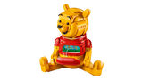 LEGO Winnie the Pooh 43300 side view showing the seated Winnie the Pooh figure with turning head arrows and an opened front panel revealing a hidden picture strip