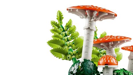 Close up of LEGO red fly agaric mushrooms with white spots and green fern pieces