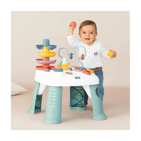 Toddler standing at Little Smoby Activity Table playing with the ball tower and shape sorter activities