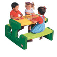 Three children drawing together at the Little Tikes picnic table with crayons and paper