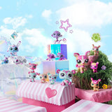 Littlest Pet Shop panda, rabbit, monkey and deer families arranged across pastel pink platforms, clear display blocks and miniature grassy scenery.