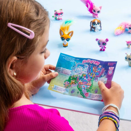 Child holding an unfolded Littlest Pet Shop collector habitat map, with colourful animal figures illustrated in the background.