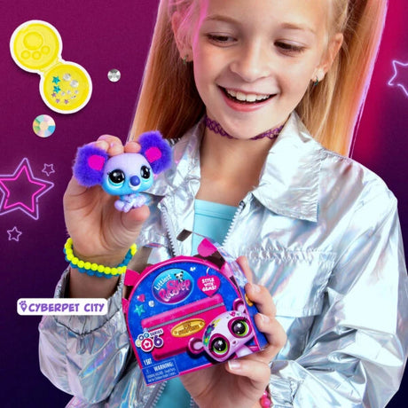 Girl holding a purple and blue Littlest Pet Shop panda figure beside a colourful pet accessory and Cyberpet City graphics.