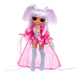 Full length view of Kitty K with high silver lilac pigtails, pink eye makeup, metallic pink jacket and shorts, shimmering blue top, pale blue lace up boots and a round silver handbag, with long sheer pink fabric flowing behind her.