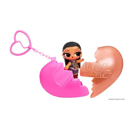 L.O.L. Surprise Music Festival Headliners Tots miniature doll with dark braided hair and a blue butterfly patterned outfit, standing inside an opened pink and rose gold heart capsule with a pink heart shaped keychain.