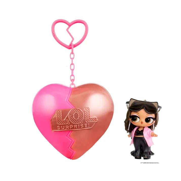 L.O.L. Surprise Music Festival Headliners Tots doll with long brown hair, oversized sunglasses resting on her head, a pink jacket, black crop top and black flared trousers, displayed beside a pink and rose gold heart capsule.
