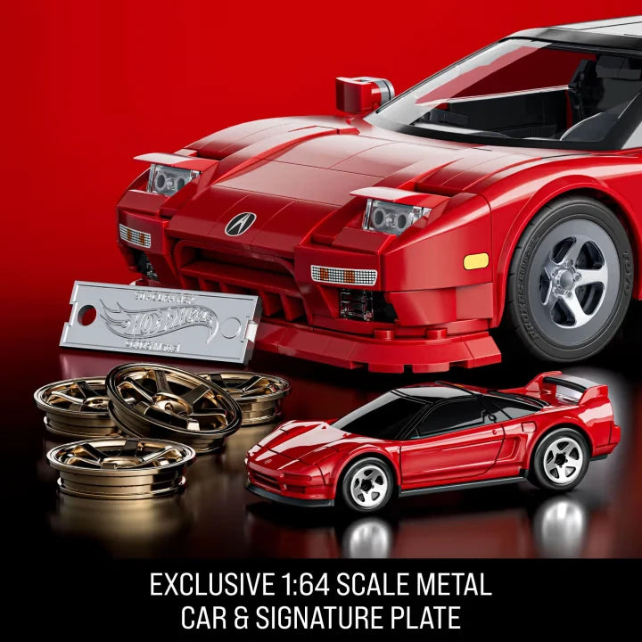 Close-up of red Hot Wheels Acura NSX model with small diecast car, signature plate and wheel covers