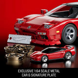 Close-up of red Hot Wheels Acura NSX model with small diecast car, signature plate and wheel covers