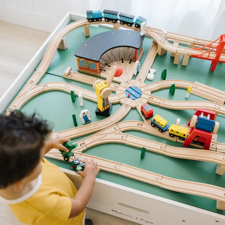 Overhead view of the Melissa & Doug Deluxe Wooden Multi-Activity Play Table with wooden train tracks, trains and buildings