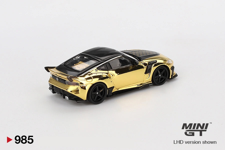 Rear three quarter view of Mini GT Nissan Z VeilSide FFZ400 Gold Chrome showing the rear spoiler, black diffuser, exhaust, gold bodywork and black racing wheels