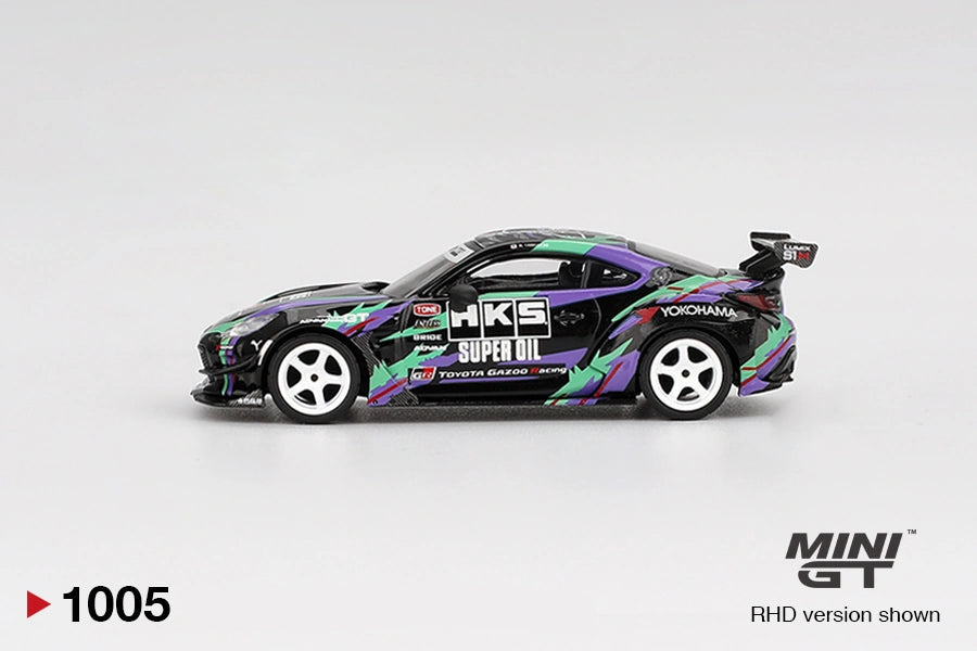 Side profile of Mini GT Toyota GR86 HKS Type R showing black bodywork, purple and green HKS graphics, white five spoke wheels, HKS Super Oil branding and large rear wing