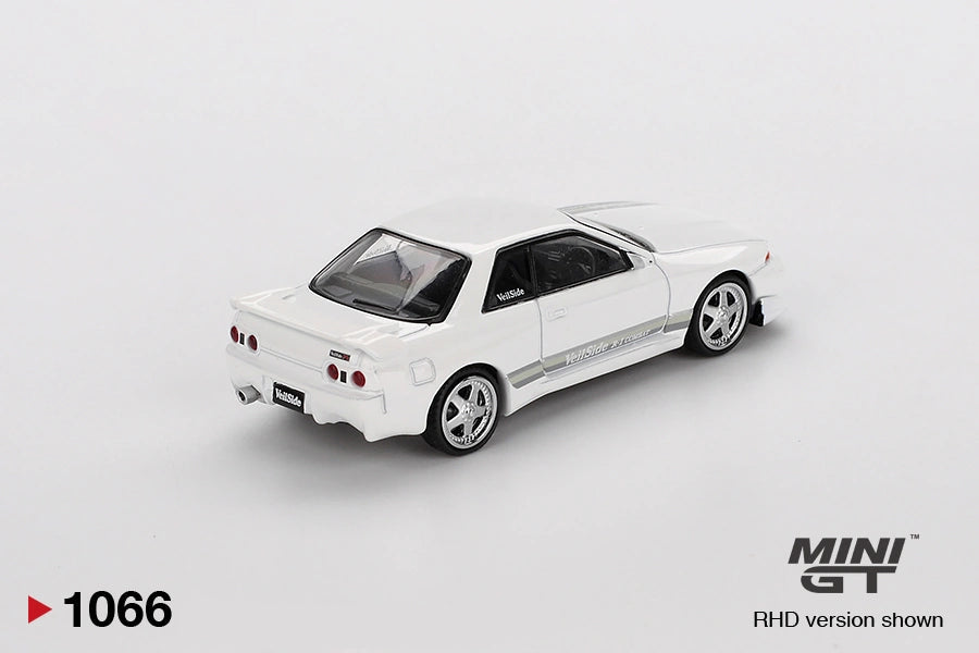 Rear three quarter view of Mini GT Nissan Skyline GT-R R32 VeilSide Combat C-I White showing four round taillights, rear spoiler, silver wheels, white bodywork and grey side stripes
