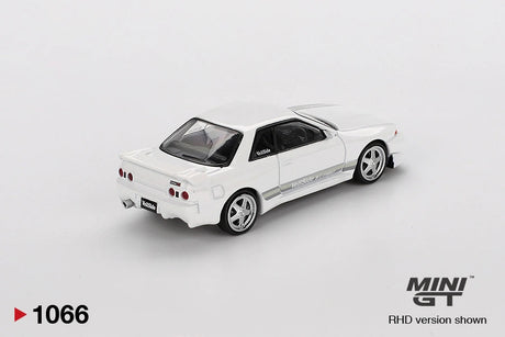 Rear three quarter view of Mini GT Nissan Skyline GT-R R32 VeilSide Combat C-I White showing four round taillights, rear spoiler, silver wheels, white bodywork and grey side stripes