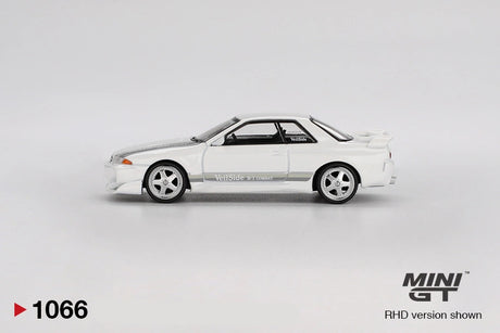Side profile of Mini GT Nissan Skyline GT-R R32 VeilSide Combat C-I White showing the silver five spoke wheels, grey VeilSide graphics, modified front bumper and raised rear spoiler