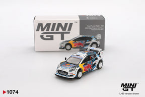 Mini GT Ford Puma Rally1 No.16 M-Sport Ford WRT 2024 Rally Finland diecast car with Red Bull racing graphics, white rally wheels and large rear wing, displayed in front of its Mini GT collector box