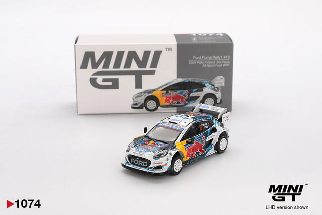 Mini GT Ford Puma Rally1 No.16 M-Sport Ford WRT 2024 Rally Finland diecast car with Red Bull racing graphics, white rally wheels and large rear wing, displayed in front of its Mini GT collector box