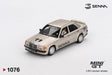 Mini GT Mercedes-Benz 190 E 2.3-16 No.11 Ayrton Senna model showing the helmeted driver figure through the window, metallic gold bodywork, SENNA windscreen banner and rear spoiler