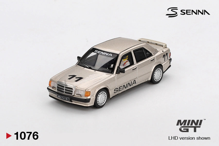 Mini GT Mercedes-Benz 190 E 2.3-16 No.11 Ayrton Senna model showing the helmeted driver figure through the window, metallic gold bodywork, SENNA windscreen banner and rear spoiler