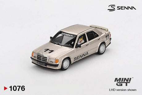 Mini GT Mercedes-Benz 190 E 2.3-16 No.11 Ayrton Senna 1984 diecast car in metallic gold, front three quarter view showing race number 11, SENNA graphics, silver wheels and Mercedes grille