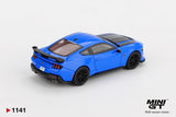 Rear three quarter view of Mini GT Ford Mustang Dark Horse 2024 Grabber Blue RHD showing the large black rear spoiler, triple vertical taillights, quad exhaust outlets and black wheels.