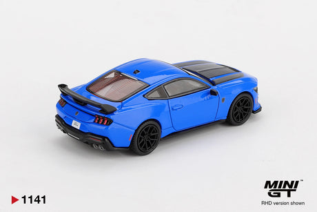 Rear three quarter view of Mini GT Ford Mustang Dark Horse 2024 Grabber Blue RHD showing the large black rear spoiler, triple vertical taillights, quad exhaust outlets and black wheels.