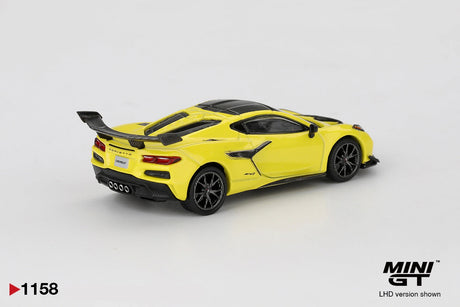 Rear three quarter view of Mini GT Chevrolet Corvette ZR1 Accelerate Yellow LHD showing the large black rear wing, Corvette lettering, four central exhaust outlets, black diffuser and rear lights.