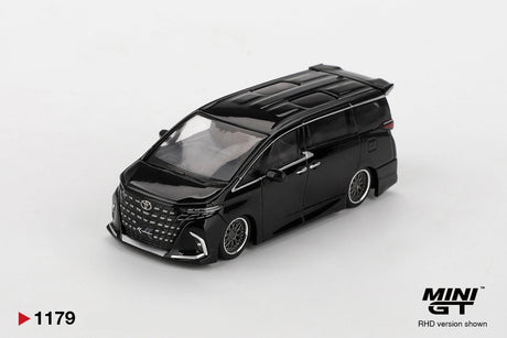 Front three quarter view of Mini GT Toyota Alphard 40 KUHL Black RHD showing the large Toyota front grille, custom front bumper, silver multi spoke wheels, roof detailing and lowered bodywork.