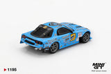Rear three quarter view of Mini GT Mazda RX-7 RE-Amemiya 2025 D1GP RHD showing round rear lights, black rear bumper, exhaust pipe, silver wheels and blue racing graphics