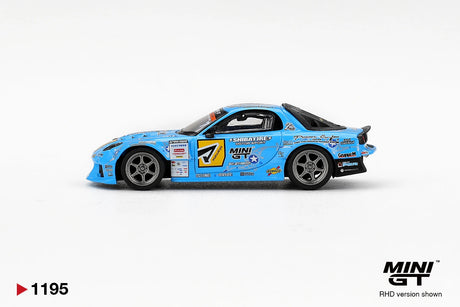 Side profile of Mini GT Mazda RX-7 RE-Amemiya 2025 D1GP RHD showing blue racing bodywork, number 7 door graphics, SHIBATIRE Motorsport branding, silver wheels and sponsor decals