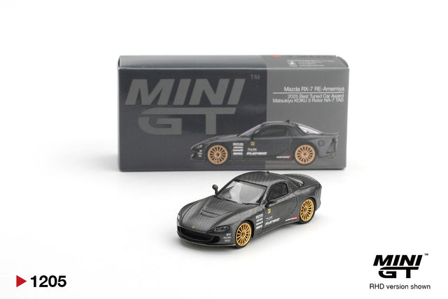 Mini GT Mazda RX-7 RE-Amemiya Matsukiyo KOKU 3 Rotor NA-7 diecast car with dark carbon effect bodywork and gold wheels, displayed in front of its illustrated Mini GT collector box