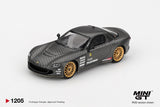 Mini GT Mazda RX-7 RE-Amemiya Matsukiyo KOKU 3 Rotor NA-7 front three quarter view showing the carbon effect bonnet, low front bumper, gold wheels and white sponsor graphics