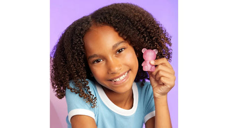 Child holding Mini Glam bear shimmer lotion keyring