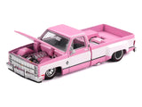 Mini GT Chevrolet Silverado Dually Vintage Spec V2 pink and white diecast pickup truck with bonnet open, showing the detailed engine, chrome grille and lowered bodywork