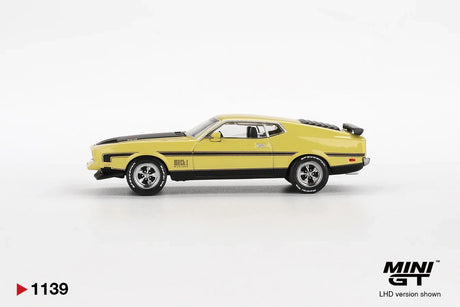 Side profile of Mini GT Ford Mustang Mach 1 Grabber Yellow LHD showing the yellow fastback body, black side stripes, Mach 1 badging, chrome wheels and raised bonnet scoop