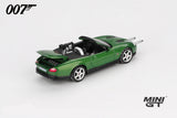 Mini GT James Bond Die Another Day Jaguar XKR green LHD prototype front three quarter view with twin silver bars extended from the front bumper, raised boot lid and rear mounted gun