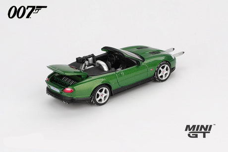 Mini GT James Bond Die Another Day Jaguar XKR green LHD prototype front three quarter view with twin silver bars extended from the front bumper, raised boot lid and rear mounted gun