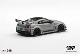 Rear three-quarter view of Mini GT Nissan LB-Silhouette WORKS GT 35GT-RR Matt Grey RHD showing four round taillights, blue exhaust tips, black rear diffuser, Liberty Walk branding and large racing wing.