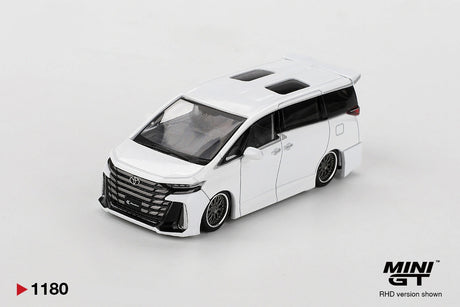 Front three-quarter view of Mini GT Toyota Vellfire 40 KUHL White RHD showing the large black Toyota grille, KUHL front bumper, lowered bodywork, custom wheels and twin roof windows.