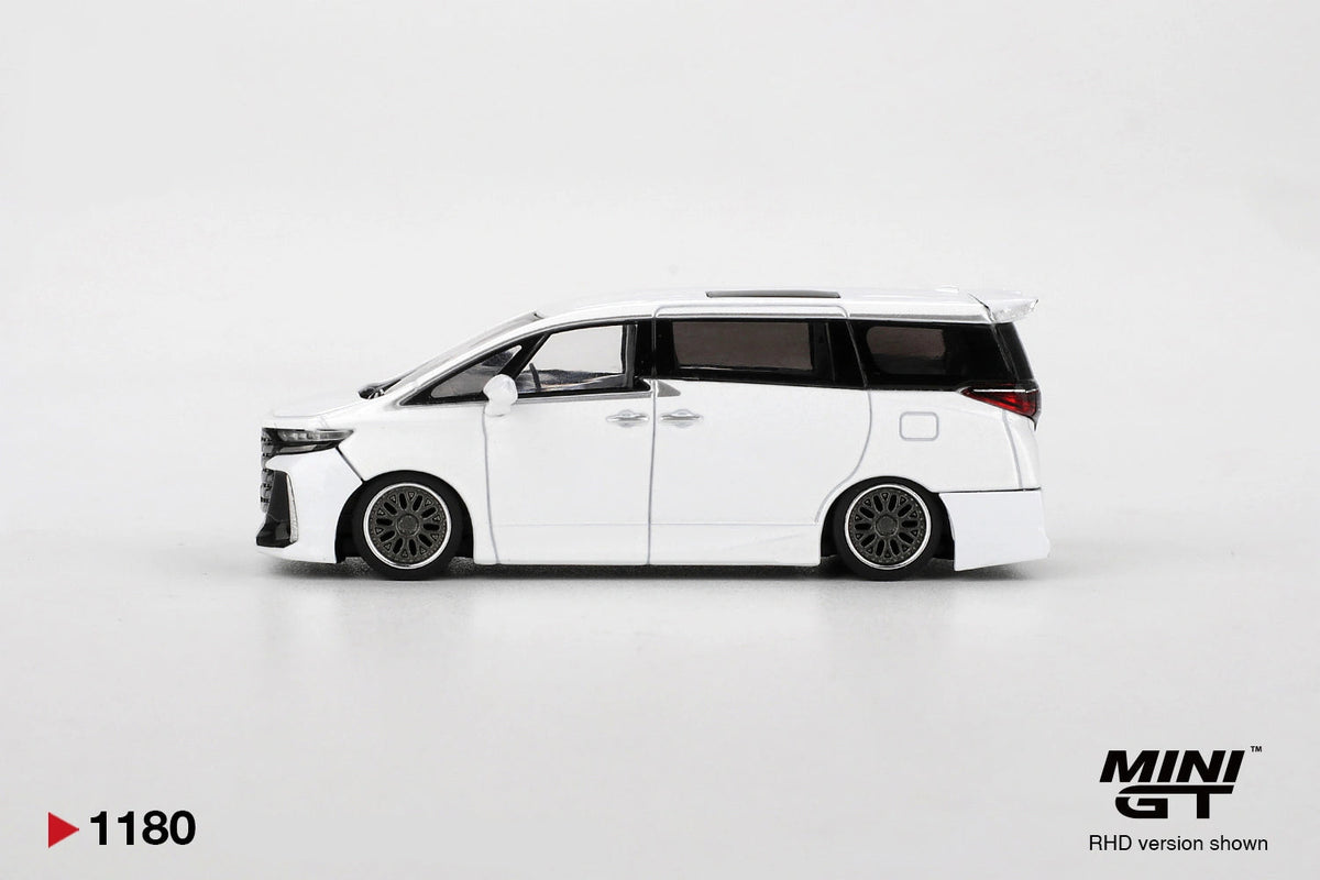 Side profile of Mini GT Toyota Vellfire 40 KUHL White RHD showing lowered suspension, dark multi-spoke wheels, black tinted windows and white bodywork.