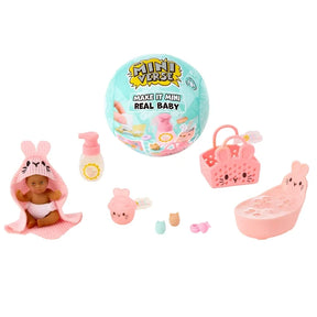 Miniverse Make It Mini Real Baby Nurture turquoise surprise capsule displayed with a miniature baby in a pink bunny hooded towel, pink bunny bath, bottle, animal face basket and tiny baby care accessories.