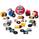 Miniverse Real Music collection display featuring a pink surprise capsule surrounded by miniature vinyl records, album covers, colourful record crates and keychains, with artwork from artists including TLC, Britney Spears, Amy Winehouse and The Beach Boys.