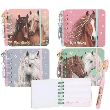 Four Miss Melody mini notebooks with different horse cover designs, plus an open notebook and a pink pen.