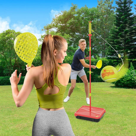Mookie Classic All Surface Swingball set on a lawn with two players holding yellow bats