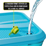 Turquoise Swingball base with yellow fill plug and water pouring into the opening