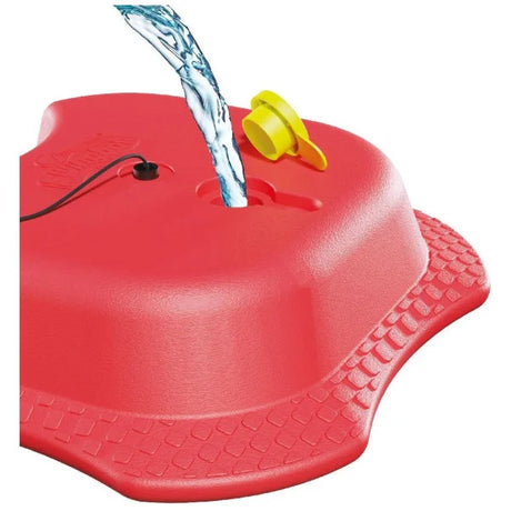 Red Mookie Reflex Tennis Trainer base with yellow fill plug and water pouring into the opening